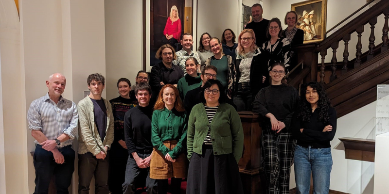 photo of the library staff standing on a staircase, smiling and looking towards the camera