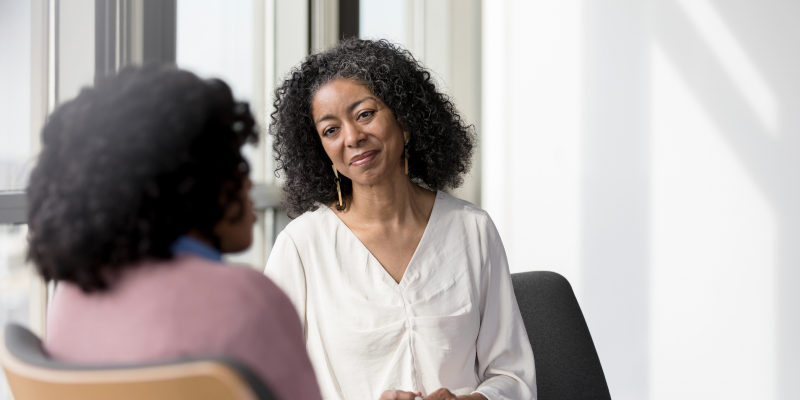 A professional and client talking in a therapy session