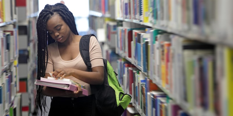Female student browsing books in a library