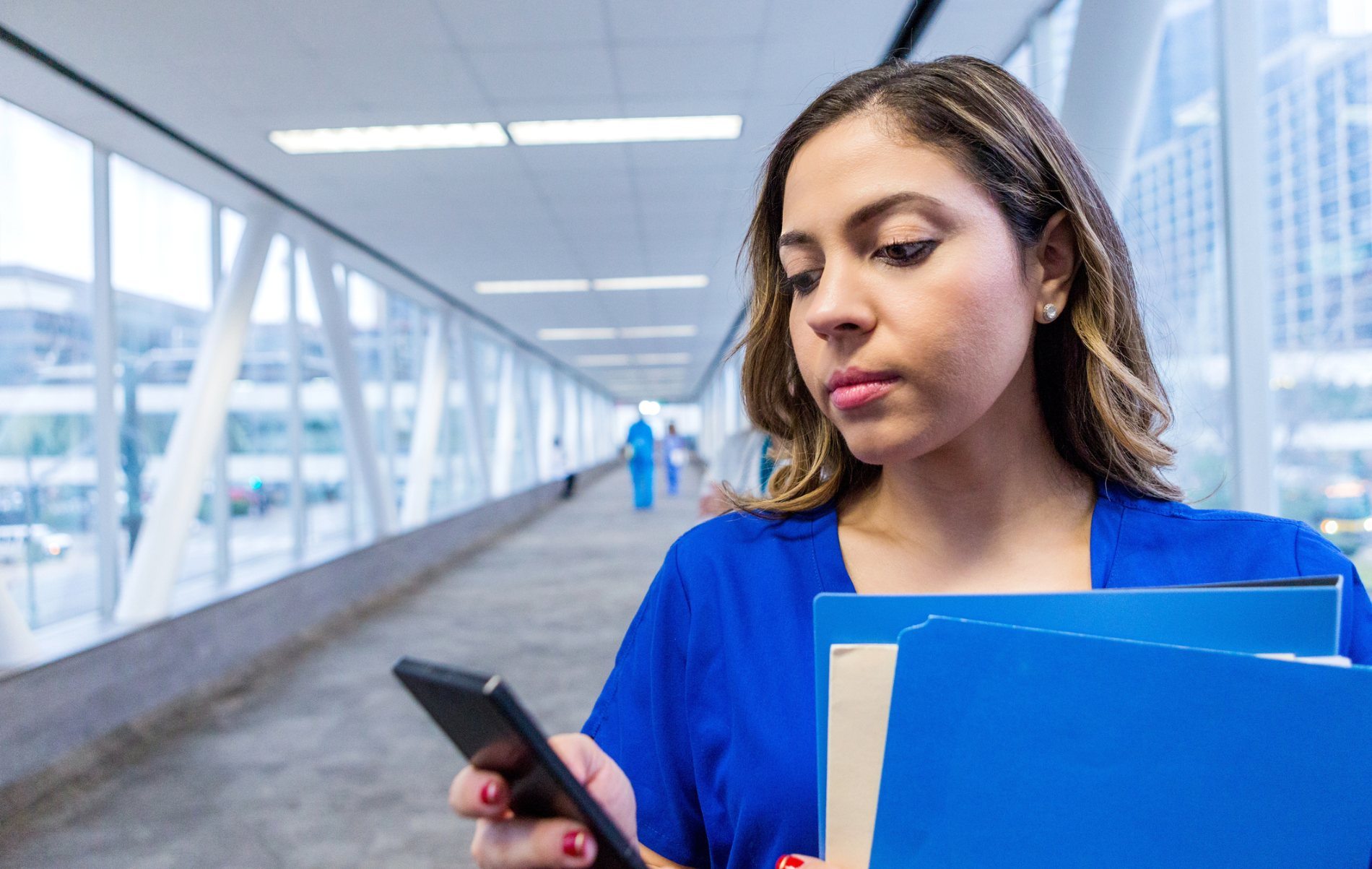Nurse holds mobile phone in her hand