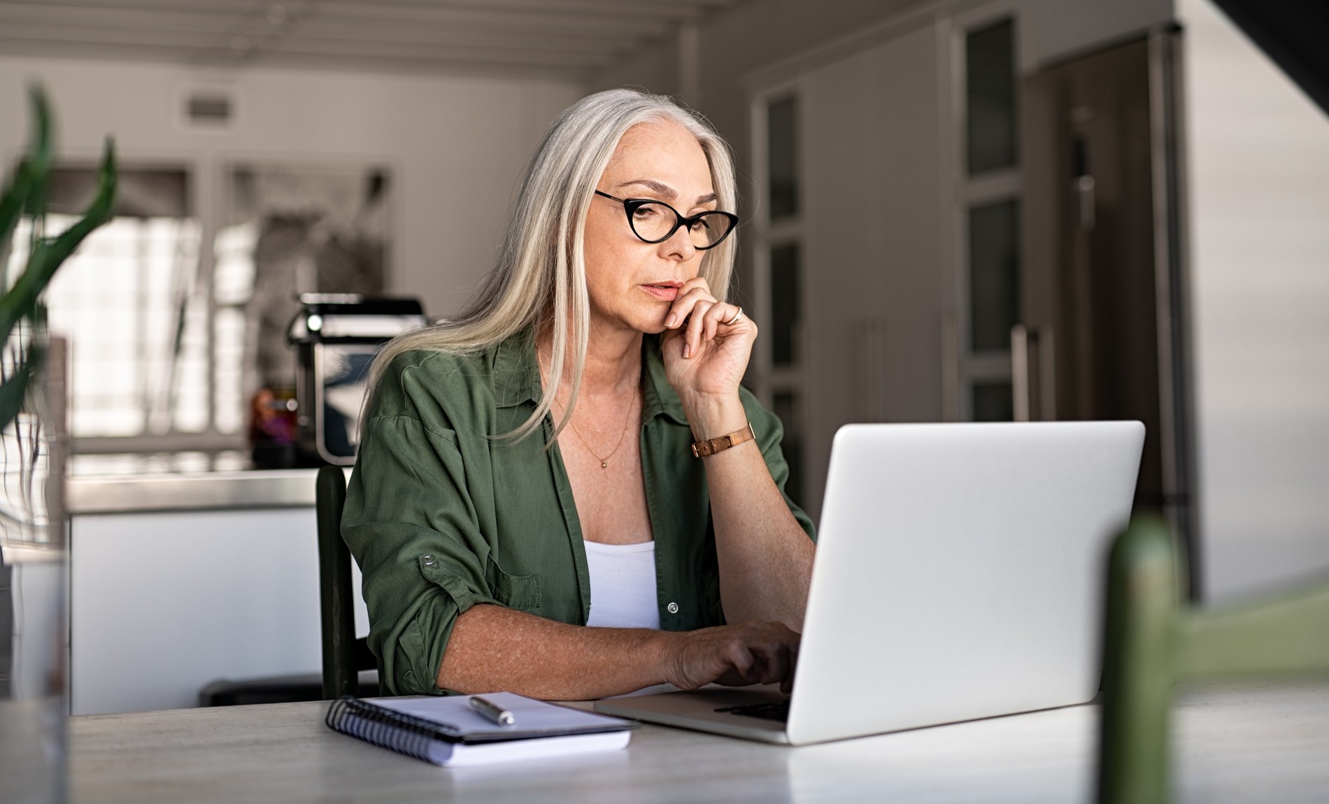 Woman sits in front of her laptop looking worried