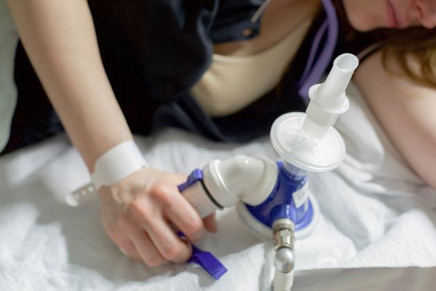 gas and air with a patient's torso in focus on a bed