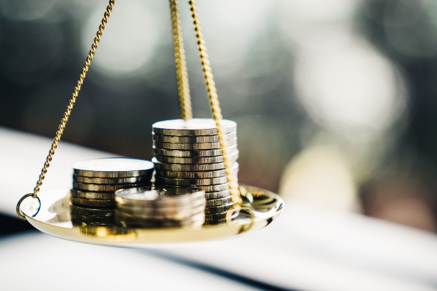 Gold coins on a traditional set of scales