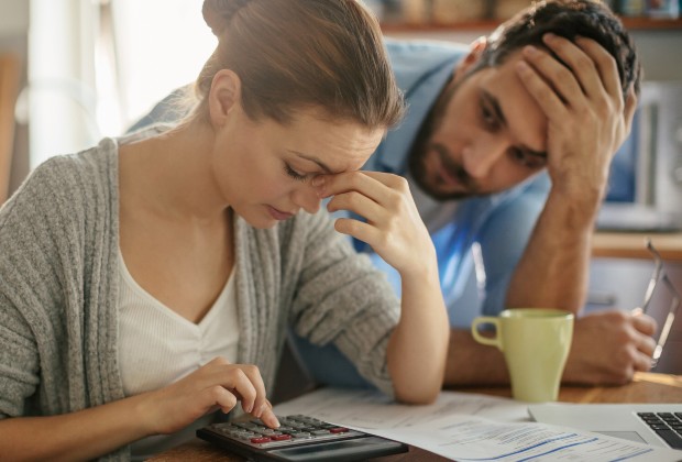 Couple looking anxiously at bills