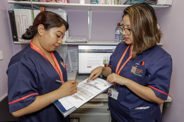 Two nursing staff looking at a form together.