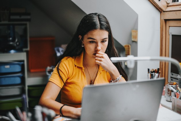 Woman looking concerned while working on a laptop