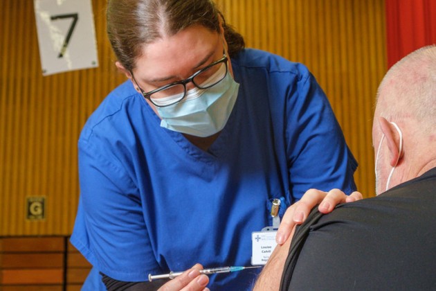 Lou Cahill vaccinating someone