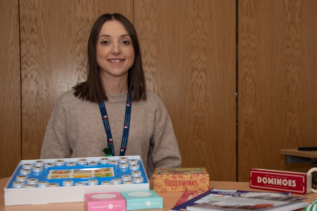 Sarah Bisp sat behind games and other equipment is uses in her dementia programme sessions