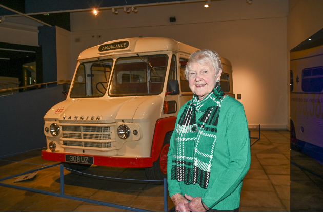 Lorna Finlay in front of an older style ambulance at Ulster Museum