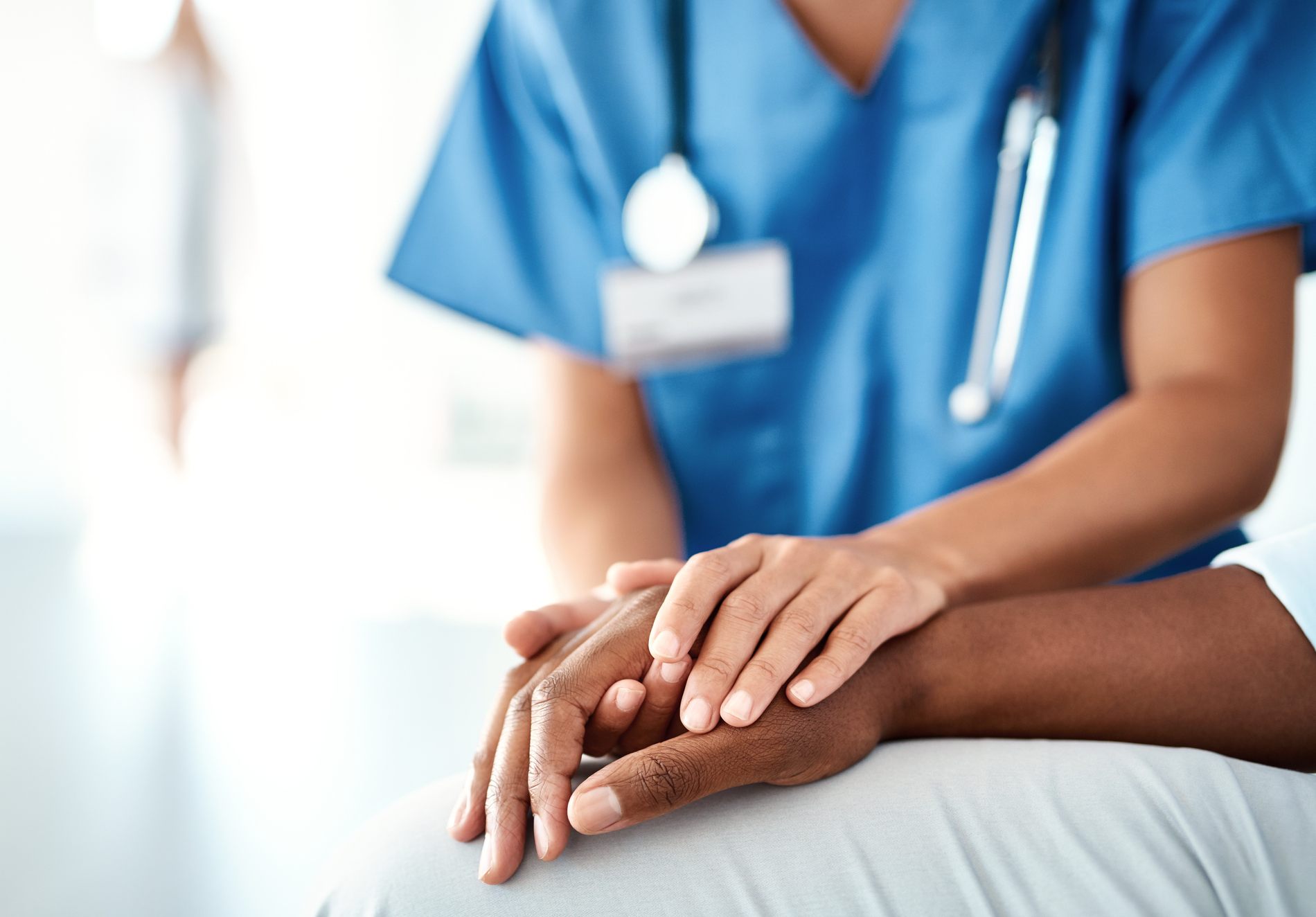 Nurse holds a patient's hand