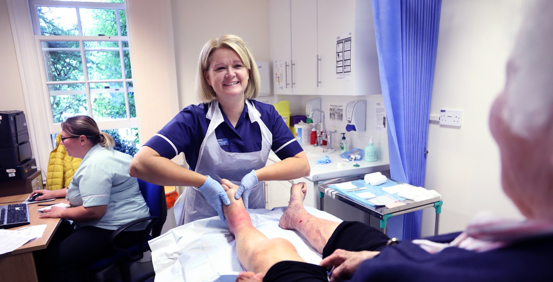 Emma Williamson tends to a patient's lower leg. She has won an RCNi Nurse Award for her work establishing a holistic wound care clinic