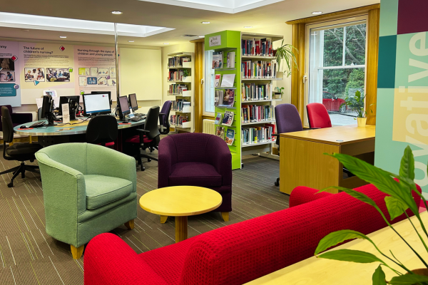 A sofa and two arm chairs in a library
